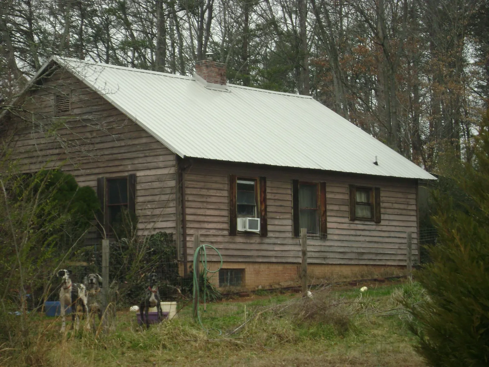 White metal roof on an old wood sided farmhouse, from a Metal Roof Installation job in Kingsland